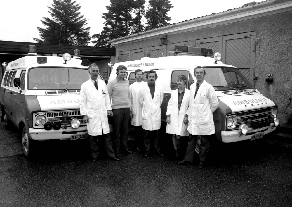 En gruppe menn som står ved siden av en lastebil