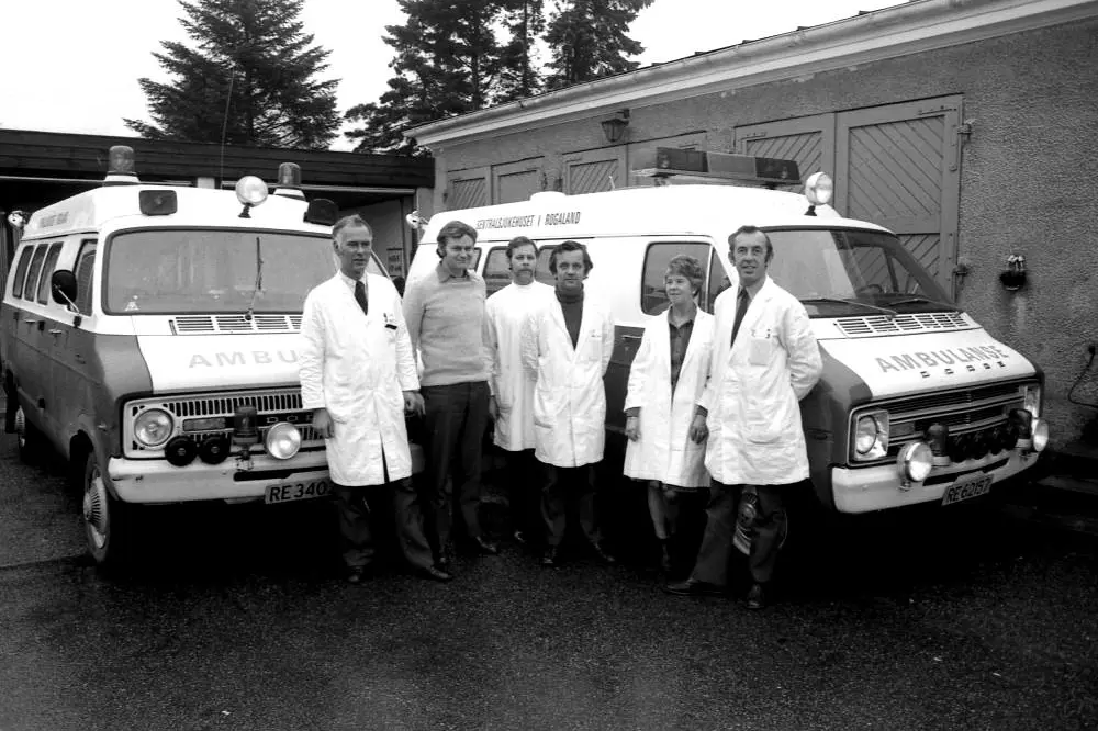 En gruppe menn som står ved siden av en lastebil