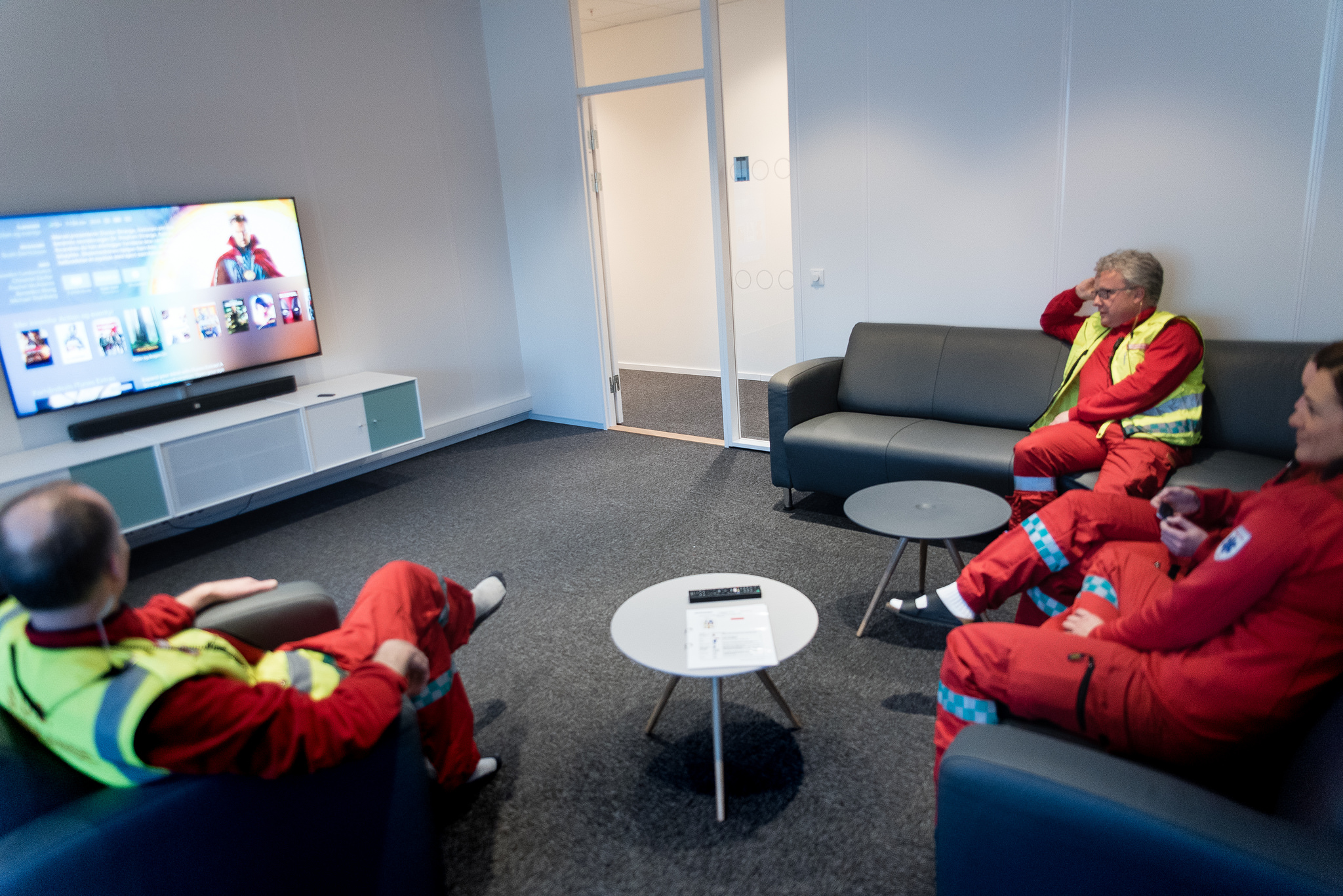 En gruppe mennesker som sitter i stoler og ser på TV