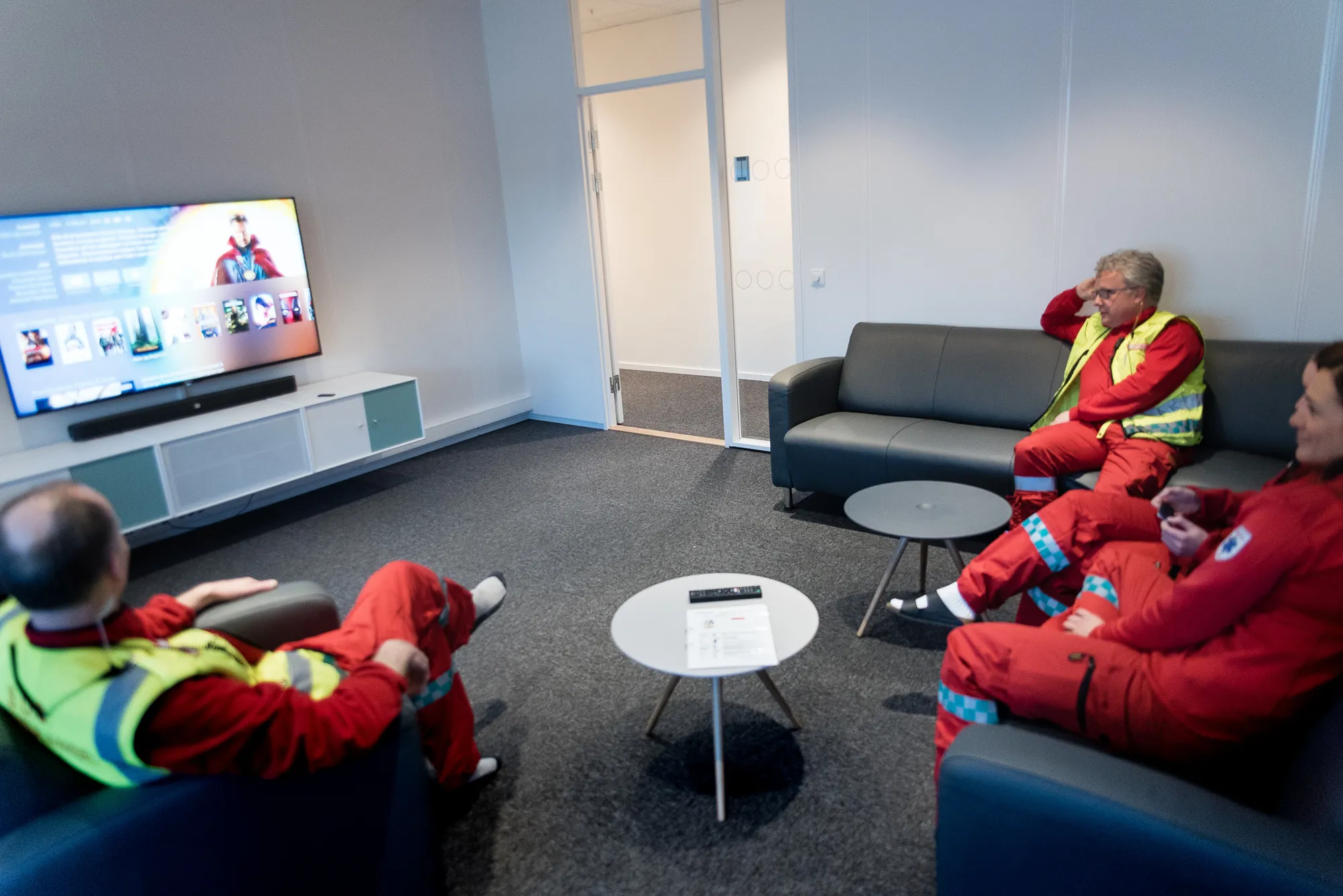 En gruppe mennesker som sitter i stoler og ser på TV
