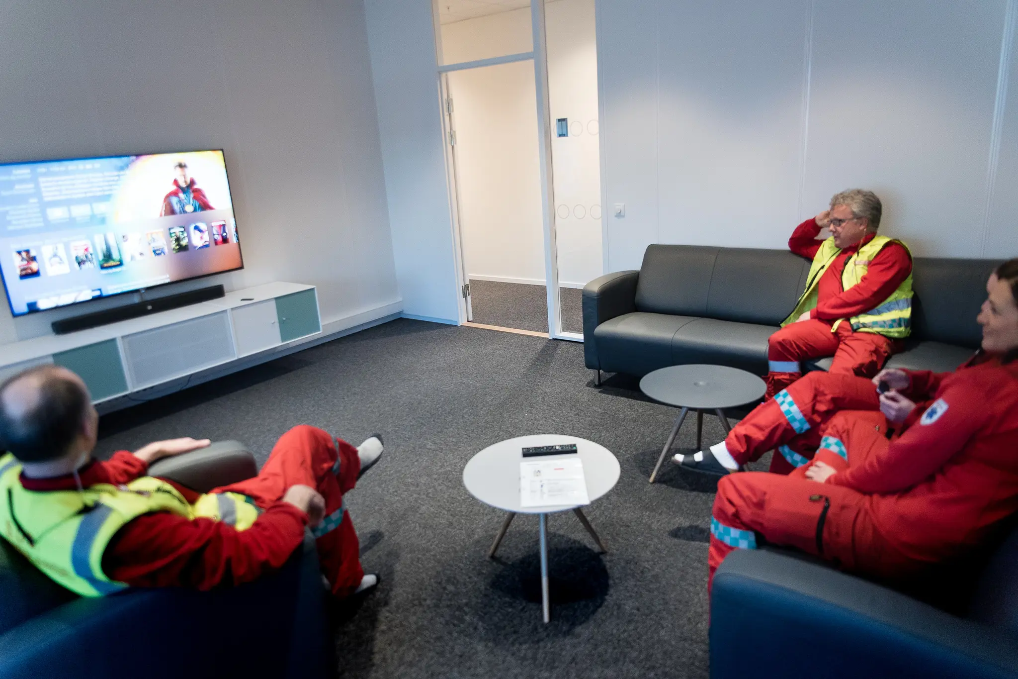 En gruppe mennesker som sitter i stoler og ser på TV