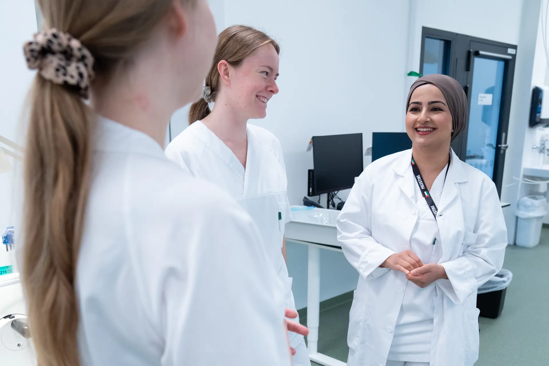 Tre kvinner snakker sammen.