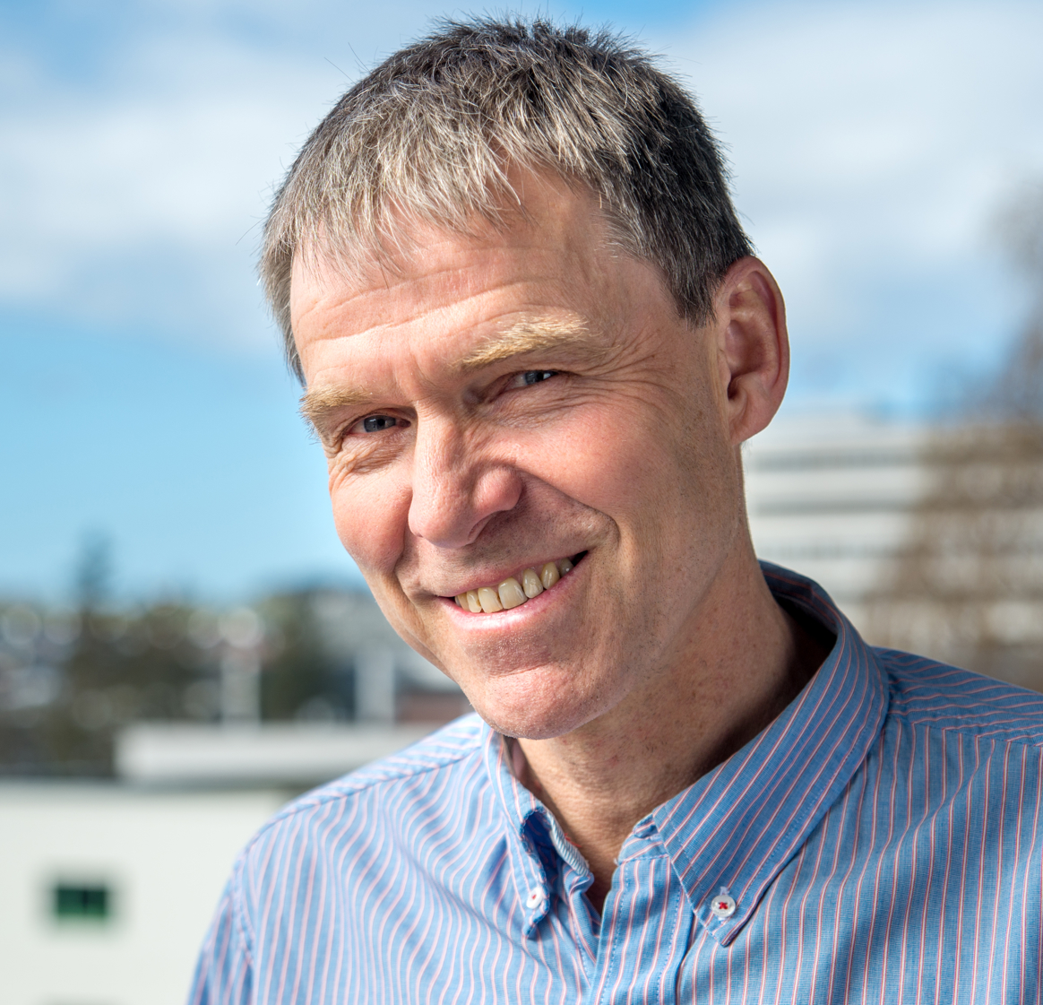 En mann som smiler til kameraet