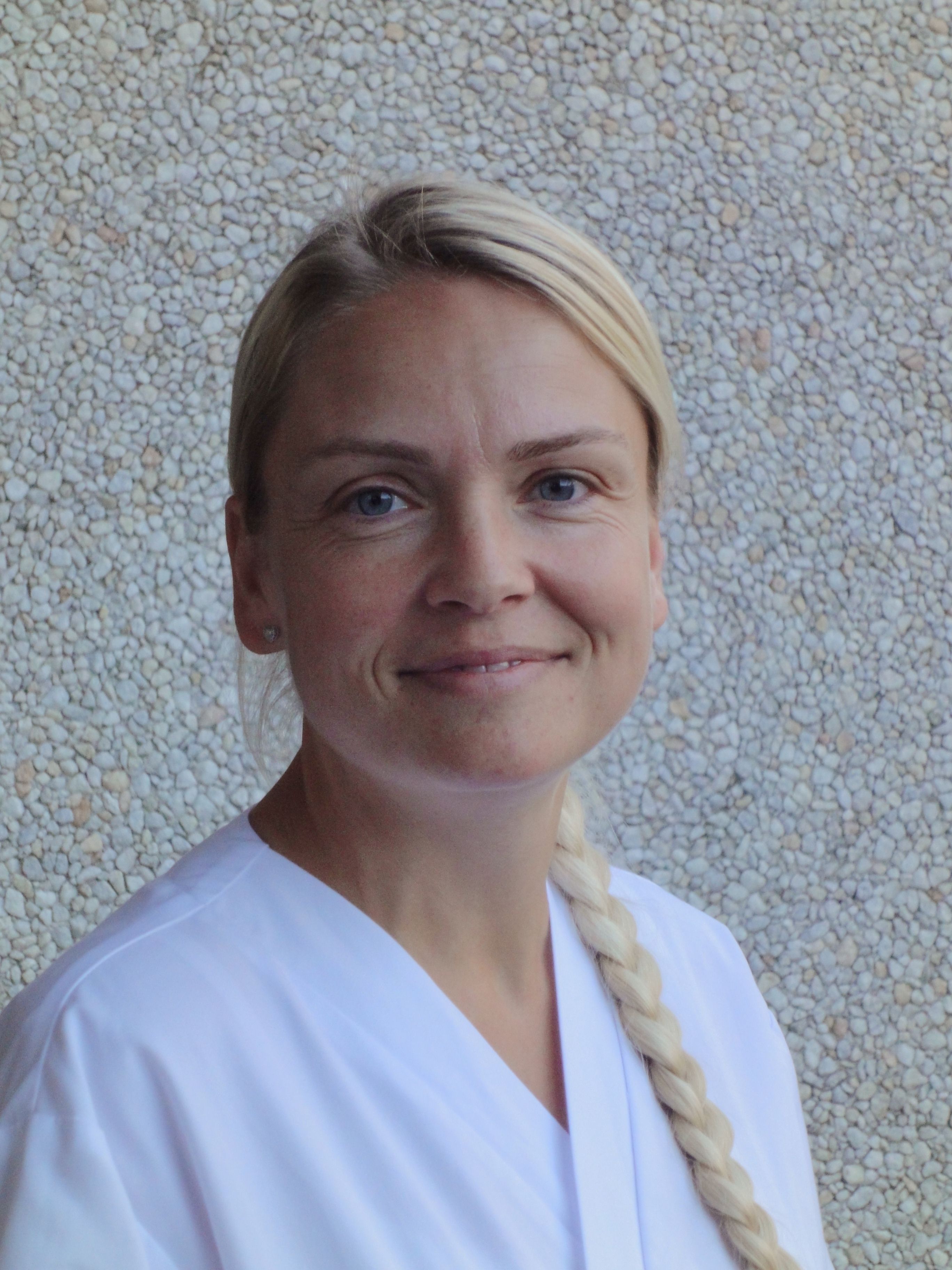 En kvinne som smiler til kameraet