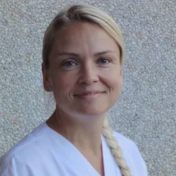 En kvinne som smiler til kameraet