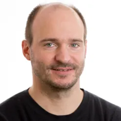 En mann som smiler til kameraet