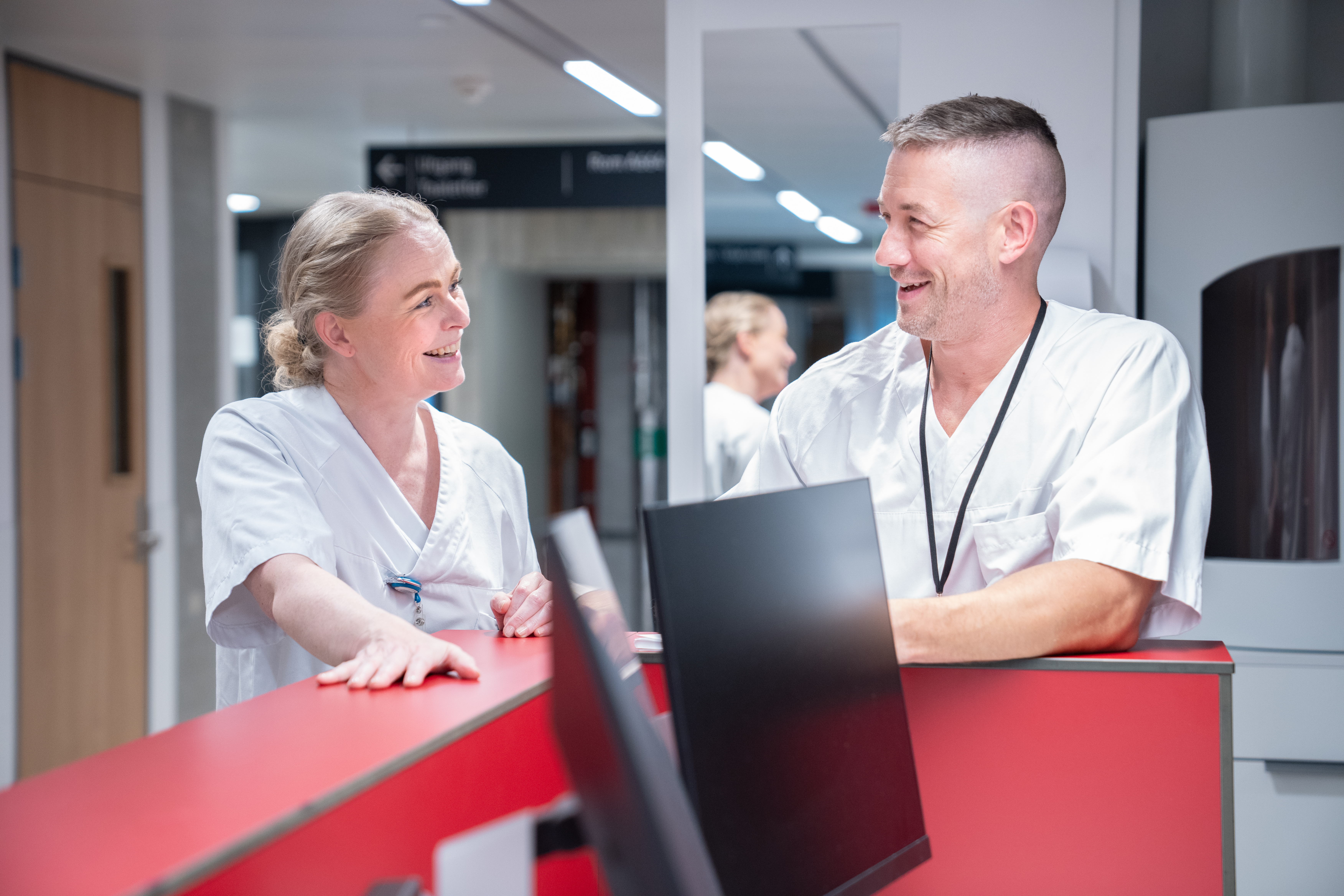 Helsepersonell som smiler til hverandre