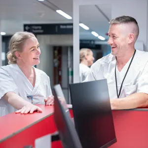 Helsepersonell som smiler til hverandre