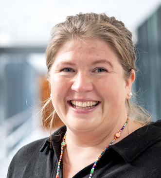 En kvinne som smiler til kameraet