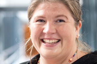 En kvinne som smiler til kameraet