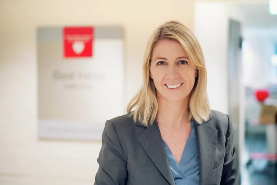 En kvinne som smiler til kameraet