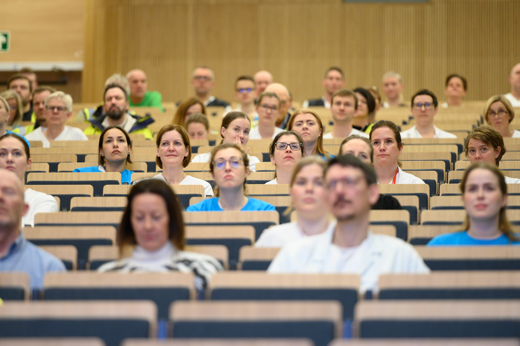En gruppe mennesker som sitter i en forelesningssal