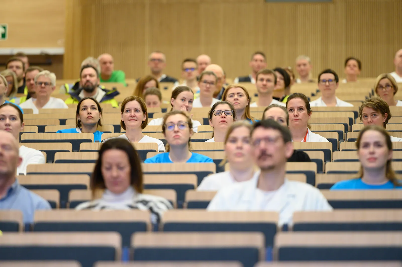 En gruppe mennesker som sitter i en forelesningssal