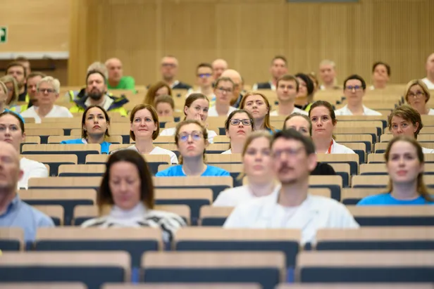 En gruppe mennesker som sitter i en forelesningssal