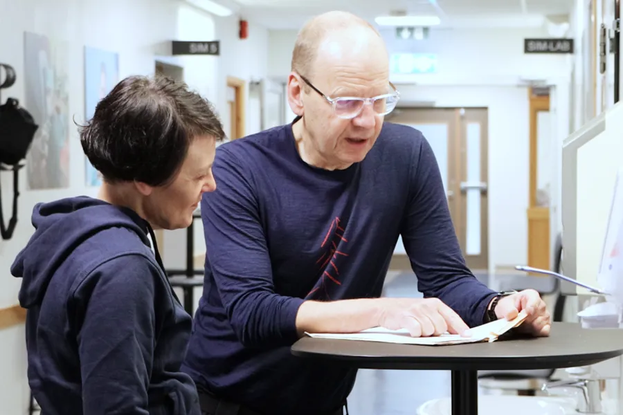 En person og en gutt som ser på et papir