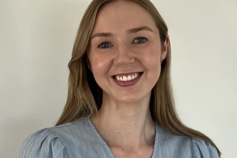 En kvinne som smiler til kameraet