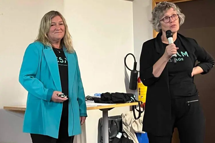 Et par kvinner som står i et rom med mikrofon