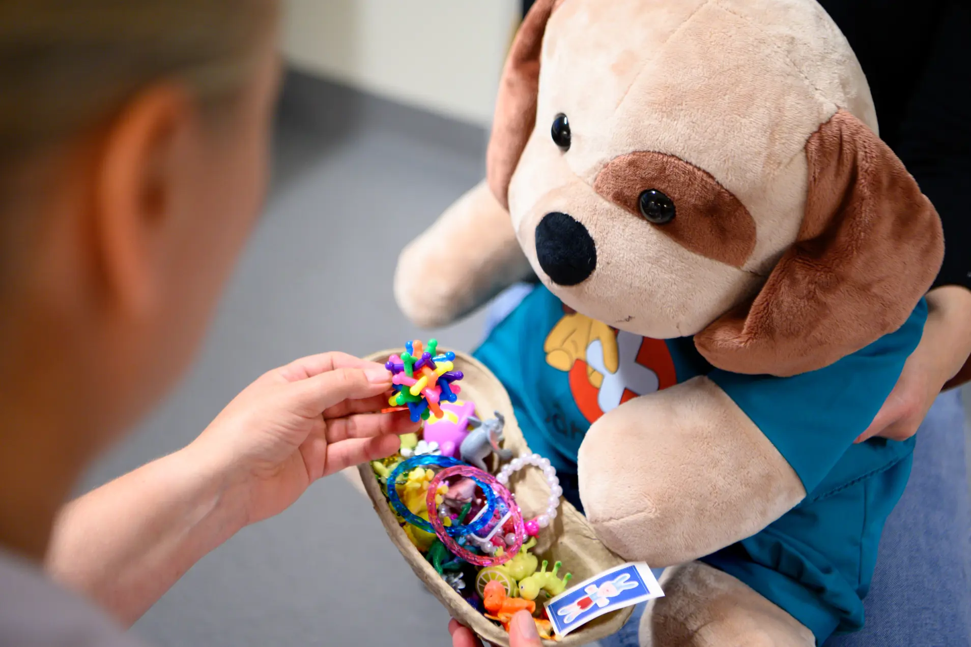 En kosebamse med en boks med leker
