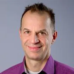 En mann som smiler til kameraet