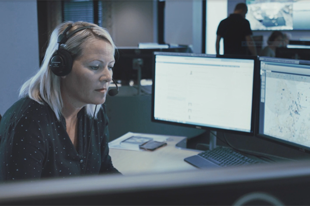 A person wearing headphones sitting at a desk with a computer