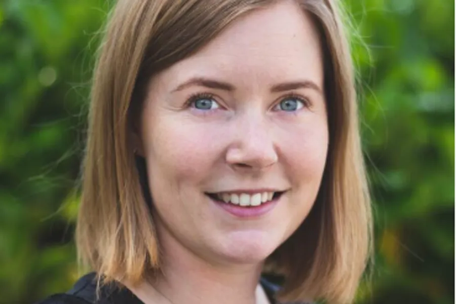En kvinne som smiler til kameraet