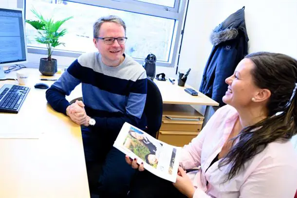 A man and a woman looking at a book